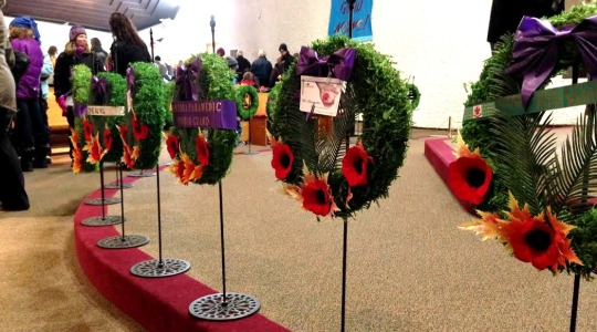 The Remembrance Day wreaths lined up at the front of the stage. 